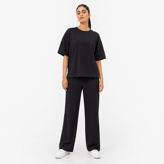 Woman wearing the Black Drop Shoulder tracksuit, front view